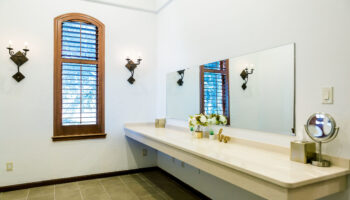 Vanity counter in the large prep suites, with long mirror and natural light coming from the open shutter windows
